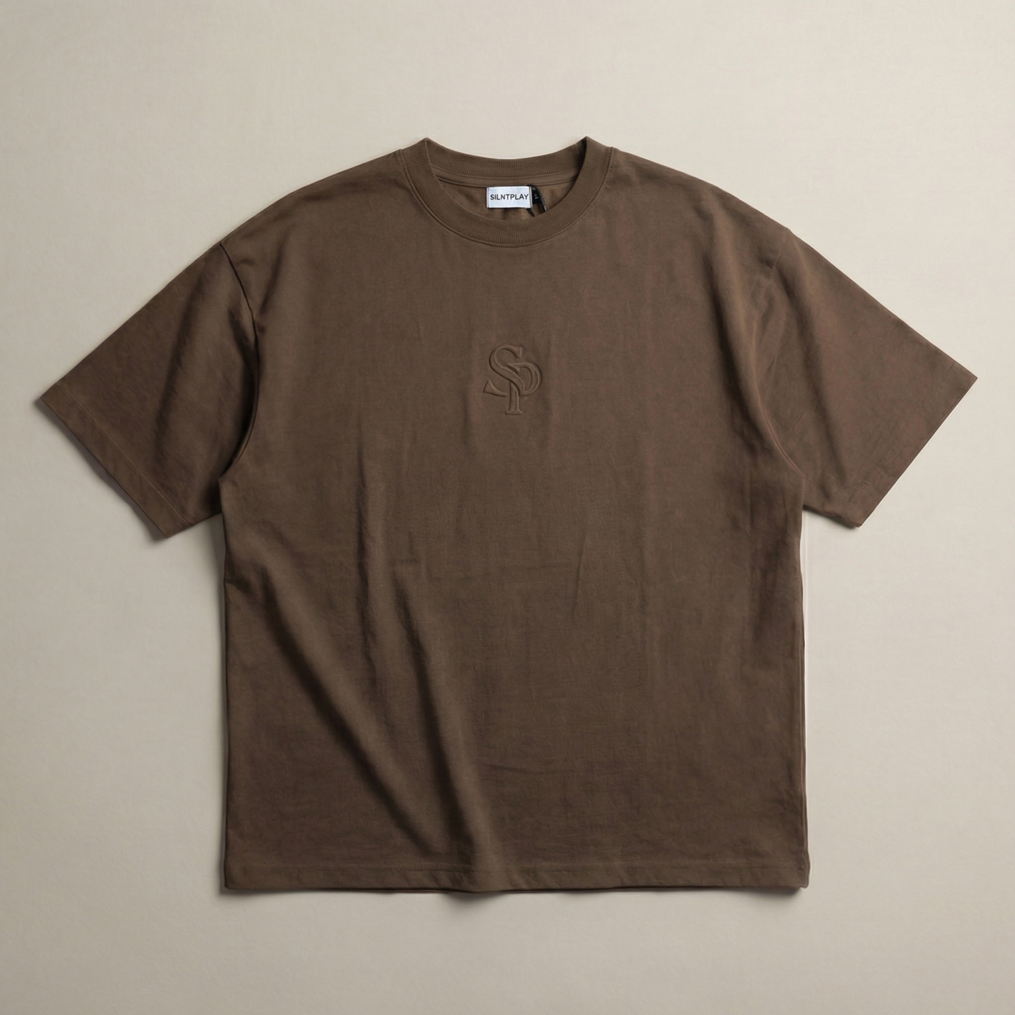 The SILNTPLAY Embossed Tee in Claystone, front flatlay